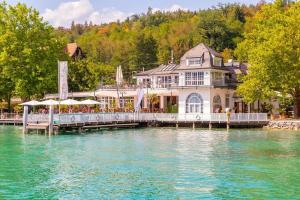 a large house on a dock on the water at Apartments Sunnseitn by Gerrit & Herfried in Krumpendorf am Wörthersee