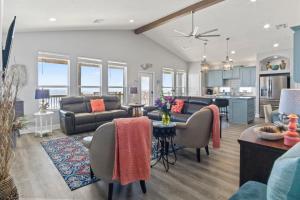 un soggiorno con un divano e un tavolo di Bella Luna - Stunning 4BR Beachfront w Cargo Lift a Bolivar Peninsula