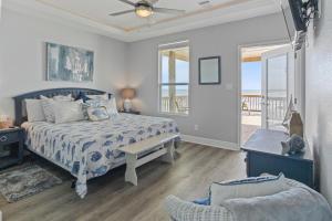 una camera con letto e sedia e un balcone di Bella Luna - Stunning 4BR Beachfront w Cargo Lift a Bolivar Peninsula