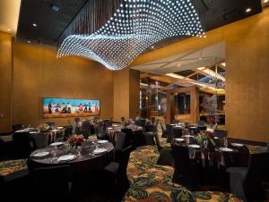 a dining room with tables and chairs and a chandelier at Choctaw Casino Resort - Durant in Durant