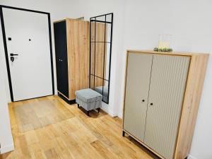 Una habitación con dos armarios y una puerta con un taburete. en MGA Apartment, en Bucarest