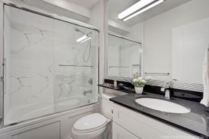 a white bathroom with a sink and a shower at Quiet Suites Up to 8 Guests Near DTVan Monthly Option in West Vancouver +13 photos
