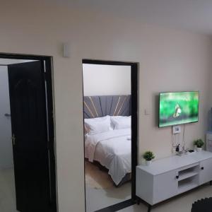 a mirror in a bedroom with a bed and a tv at Maggies suites and Bnb in Nairobi