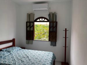 a bedroom with a bed and a window at Pousada Recanto do Japa in Nilo Peçanha