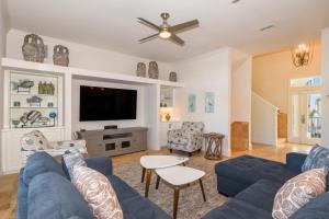 a living room with a blue couch and a tv at Casa Di Amore in Destin