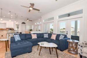 a living room with a blue couch and a kitchen at Casa Di Amore in Destin
