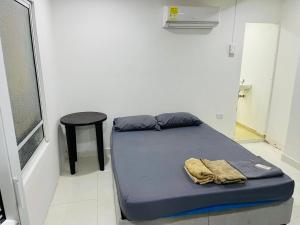 卡塔赫纳Habitación cerca a la playa 105的一张小床,位于一个带凳子和床的房间里