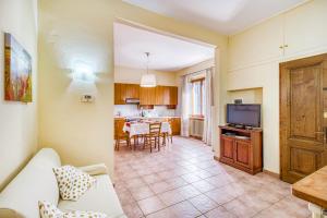 Una sala de estar con un sofá y un televisor. en Homes Boccaccio Beautiful Terrace - Happy Rentals, en Montespertoli