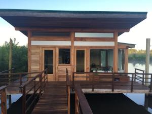 a wooden house on the water with a dock at Casa flotante en el delta, tigre in Ingeniero Maschwitz
