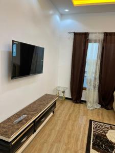 a living room with a flat screen tv on the wall at Appartement meublé saint louis - Bango in Dakar Bango