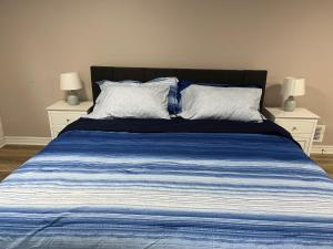 1 cama de rayas azul y blanco con 2 mesitas de noche en Crystal Beach home in Niagara, en Fort Erie