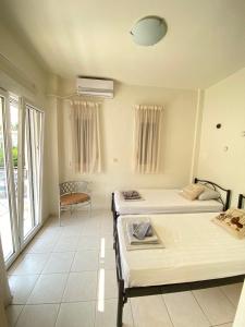 a room with two beds and a chair in it at Villa Primavera in Hanioti