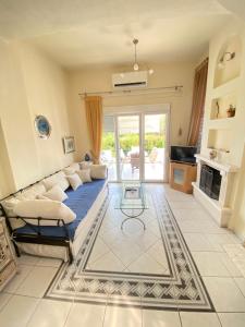 a living room with a couch and a fireplace at Villa Primavera in Hanioti