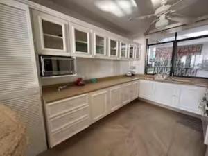 a large kitchen with white cabinets and a window at Departamento con vista espectacular Anahuac in Acapulco
