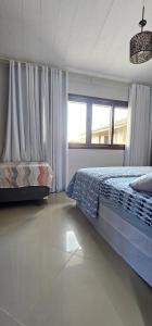 un dormitorio con una cama y una ventana en Residencial Hannah - Casa 6 - Porto Belo SC - Bairro Perequê, en Porto Belo