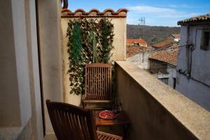 balkon ze stołem i krzesłem w budynku w obiekcie Casa Rural Doña Sol w mieście Montánchez