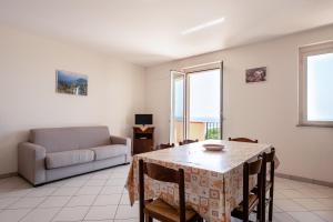 a living room with a table and a couch at Case Vacanza Alega Mare in Nizza di Sicilia