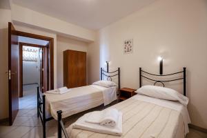 a bedroom with two beds with towels on them at Case Vacanza Alega Mare in Nizza di Sicilia