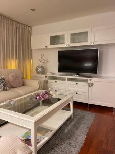 een woonkamer met een bank en een flatscreen-tv bij Apartamento Balcón a la Basílica del Pilar in Zaragoza