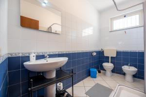 a blue and white bathroom with a sink and toilet at Case Vacanza Alega Mare in Nizza di Sicilia +81 photos