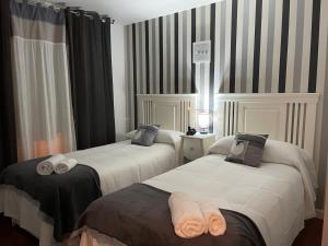 twee bedden met handdoeken erop in een kamer bij Apartamento Balcón a la Basílica del Pilar in Zaragoza