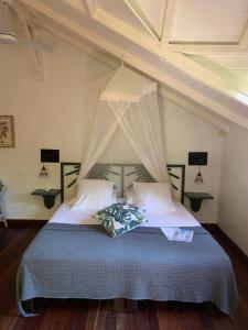 a bedroom with a bed with a canopy at Caraib'Bay Hotel in Deshaies
