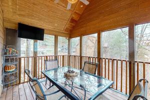 a screened in porch with a glass table and chairs at Lost Creek Haven in Branson West