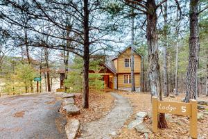 a log home with a sign in front of it at Lost Creek Haven in Branson West
