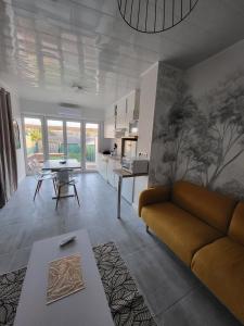 a living room with a couch and a table at Maison 4p, parking, terrasse, jardin in Chancenay