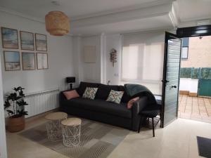 a living room with a couch and two tables at Apartamento L' Espumeru in Posada de Llanes