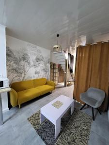 a living room with a yellow couch and a table at Maison 4p, parking, terrasse, jardin in Chancenay