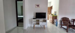 a living room with a tv and a tv stand with a television at Casa da Ilha de Boipeba in Ilha de Boipeba