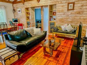a living room with a leather couch and a table at La maison de Mamie in Pessac