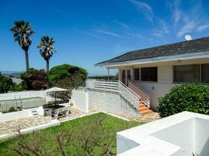 a white house with stairs and palm trees at Durbanville Queens and Kings Guest House in Cape Town