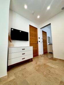 a living room with a tv on a white wall at Sunny Coast Guesthouse in Tewantin