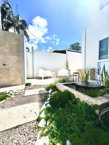 a garden with a white wall and a white chair at Sunny Coast Guesthouse in Tewantin +4 photos