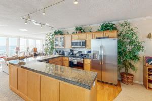 a kitchen with wooden cabinets and a stainless steel refrigerator at Ocean Star in Depoe Bay +28 photos