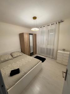 a white bedroom with a bed and a window at Maison des rivages 3 chambres in Saint-Géréon