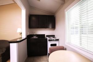 uma pequena cozinha com um fogão e um lavatório em Tri-Valley Inn & Suites em Pleasanton