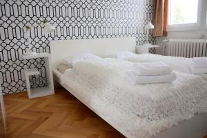 ein weißes Schlafzimmer mit einem großen Bett mit weißer Bettwäsche in der Unterkunft Classical House in Prague 6 in Prag