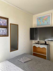1 dormitorio con 1 cama y TV de pantalla plana grande en Habitación Metro Escuela Militar, en Santiago