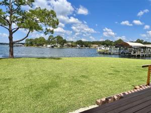 a large grassy field next to a lake with a tree at Bayou 565 - Panhandle Paradise in Marietta