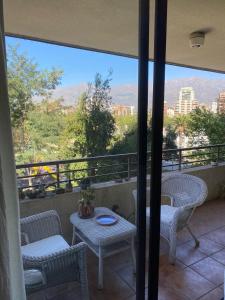 Un balcón con mesa y sillas y una vista en Habitación Metro Escuela Militar, en Santiago