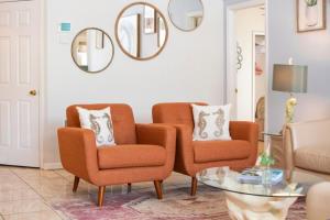 a living room with two chairs and a table at Super Mario Hideaway - Pool, Spa, Game Room Fun! in Davenport
