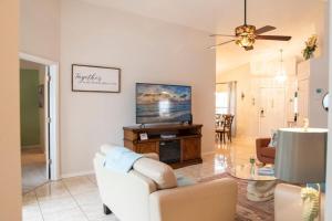 a living room with a white couch and a tv at Super Mario Hideaway - Pool, Spa, Game Room Fun! in Davenport +42 photos