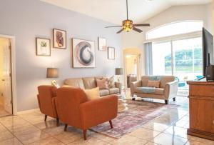a living room with a couch and a tv at Super Mario Hideaway - Pool, Spa, Game Room Fun! in Davenport