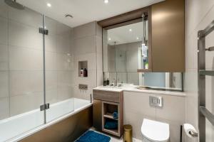a bathroom with a tub and a sink and a toilet at Modern & Cosy Flat in Kingston in Kingston upon Thames +61 photos