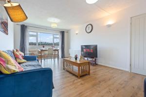 a living room with a blue couch and a table at Luxury 2 Bedroom Apartment with Free Parking Opposite Queen Elizabeth Hospital in Birmingham