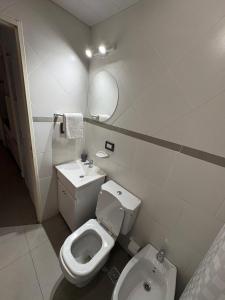 a white bathroom with a toilet and a sink at Torre Santana in San Luis +10 photos