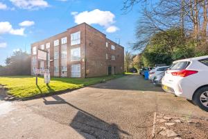 a brick building with cars parked in front of it at Luxury 2 Bedroom Apartment with Free Parking Opposite Queen Elizabeth Hospital in Birmingham